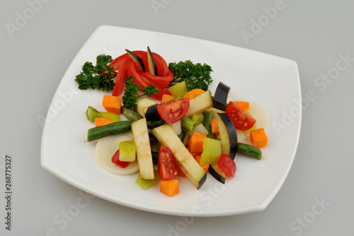 Different green vegetables on the plate gray background