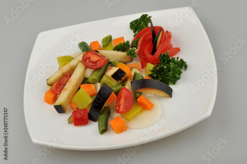 Different green vegetables on the plate gray background