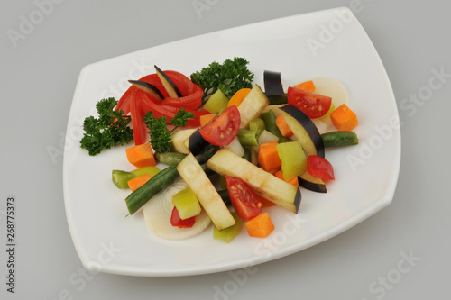 Different green vegetables on the plate gray background