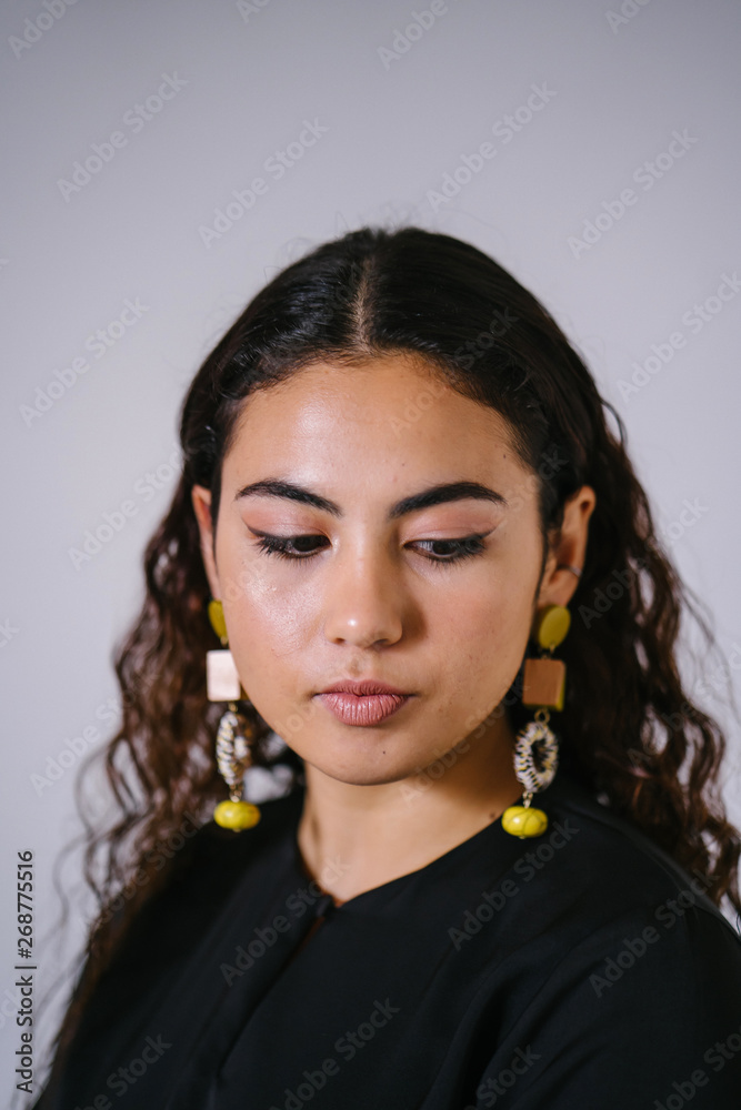 Studio portrait of a beautiful, young and attractive Malay Asian woman in a traditional black dress (Baju Kurung) for Raya (Eid) against a white background. She is youthful and radiant. Studio portrait of a beautiful, young and attractive Malay Asian woman in a traditional black dress (Baju Kurung) for Raya (Eid) against a white background. She is youthful and radiant.