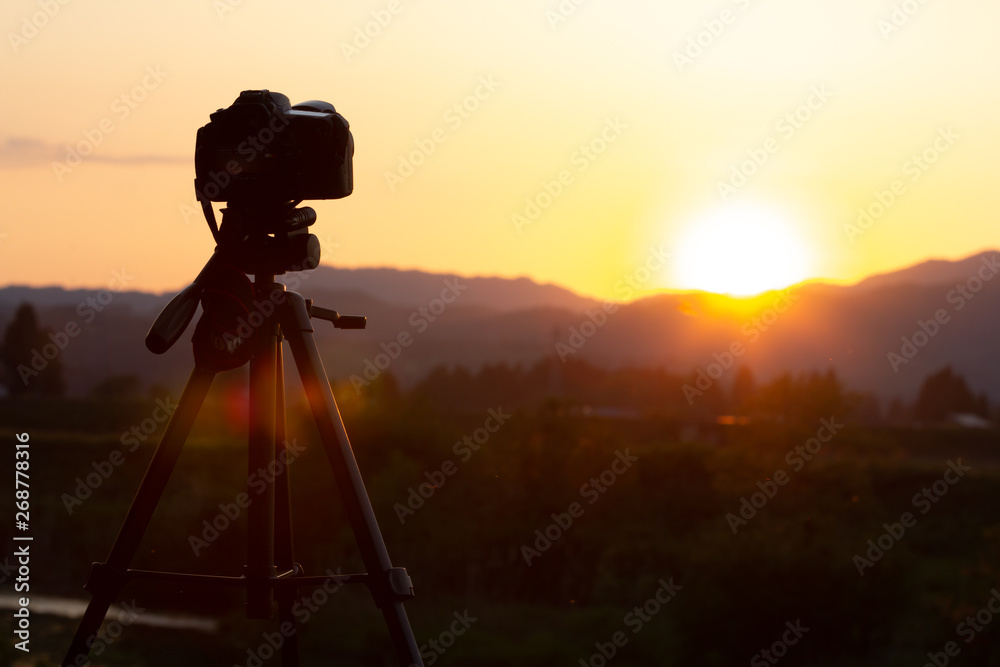 デジタル一眼レフカメラで美しい夕日を撮影している