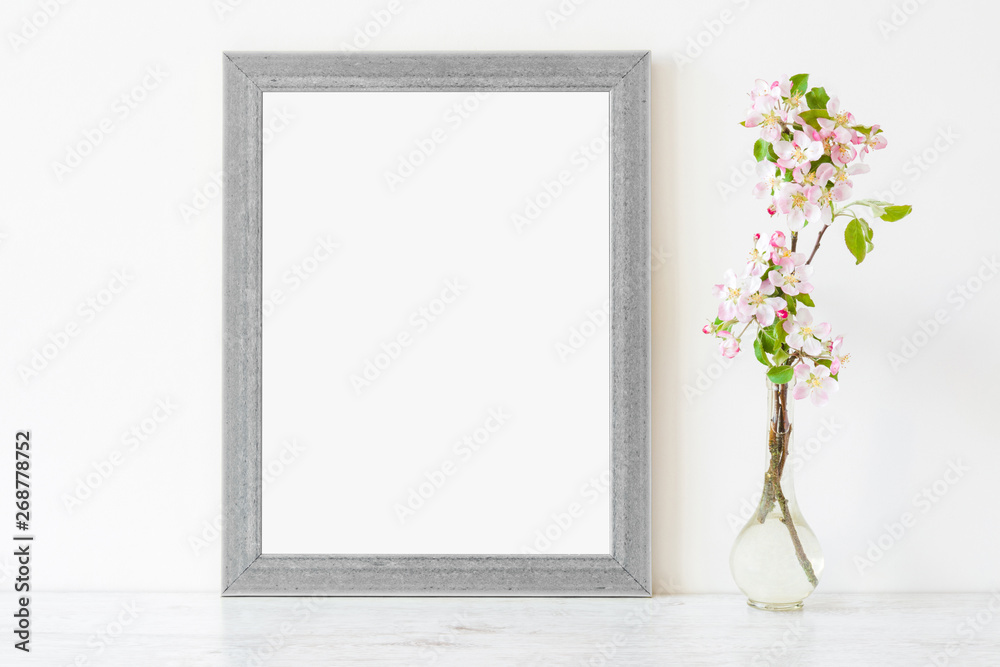 Fresh branches of pink white apple blossoms in glass vase on table at light gray wall. Empty place for inspirational, emotional, sentimental text, lovely quote or sayings in frame. Front view. 