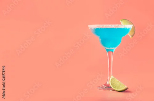 Obraz Niebieski margarita egzotyczny koktajl alkoholowy z tequilą, likierem, sokiem z limonki, solą i lodem, letnie niebieskie tło, miejsce na tekst