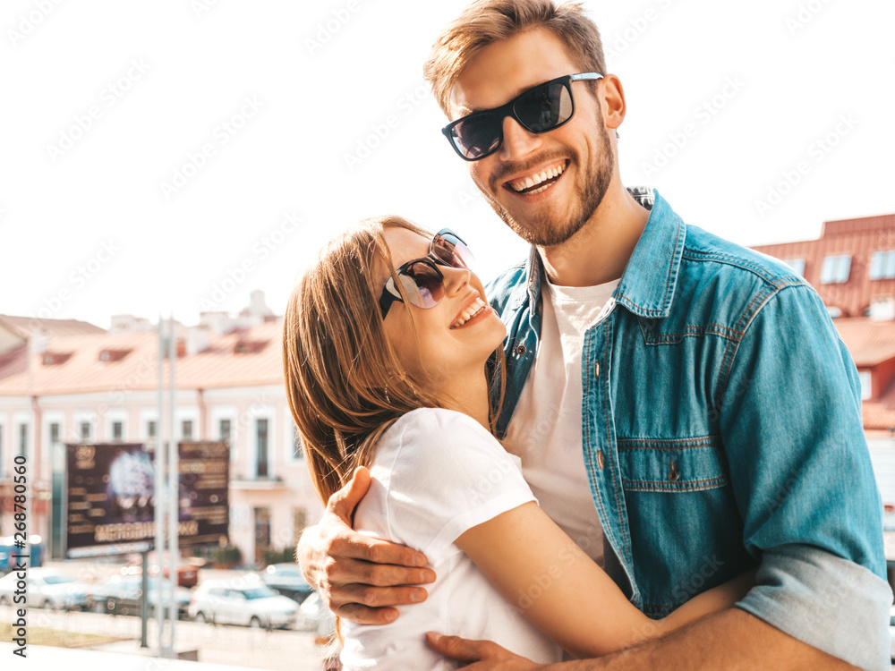 Portrait of smiling beautiful girl and her handsome boyfriend. Woman in casual summer jeans clothes. Happy cheerful family. Female having fun on the street background in sunglasses Portrait of smiling beautiful girl and her handsome boyfriend. Woman in casual summer jeans clothes. Happy cheerful family. Female having fun on the street background in sunglasses