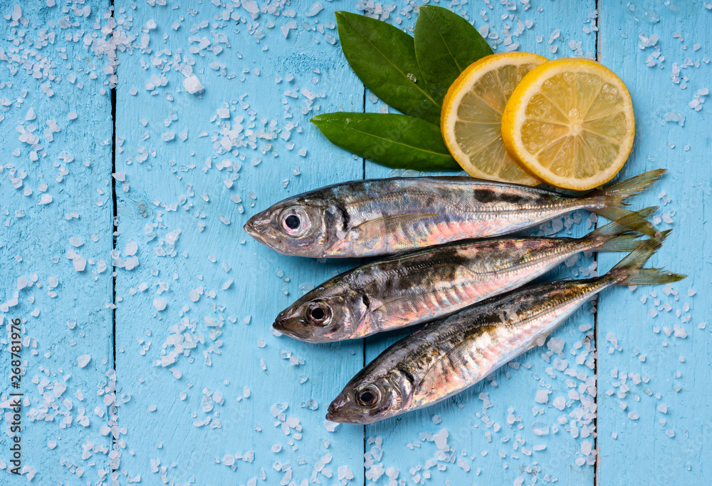 mackerel fish on blue board ground with lemon and leaf mackerel fish on blue board ground with lemon and leaf