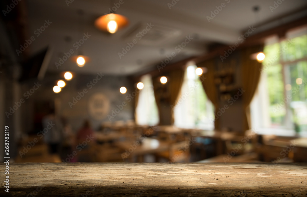 Empty wooden table in front of abstract blurred background of coffee shop . can be used for display or montage your products.Mock up for display of product Empty wooden table in front of abstract blurred background of coffee shop . can be used for display or montage your products.Mock up for display of product