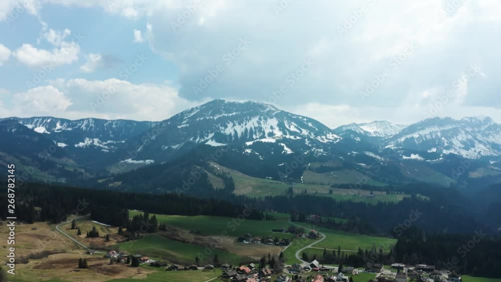 aerial view of mountain scenery with little village in switzerland entlebuch, snow covered mountain during spring aerial view of mountain scenery with little village in switzerland entlebuch, snow covered mountain during spring