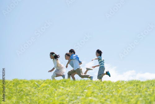 草原を走る小学生 photo