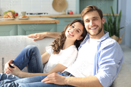 Portrait of cute young couple sitting in sofa.