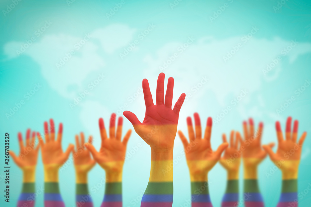 LGBT equal rights movement and gender equality concept with rainbow flag on people's hands up