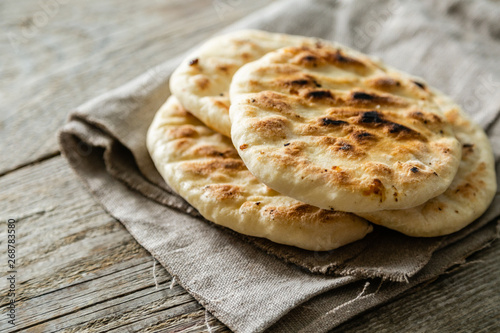 Traditional pita bread on rustic wood background, copy space