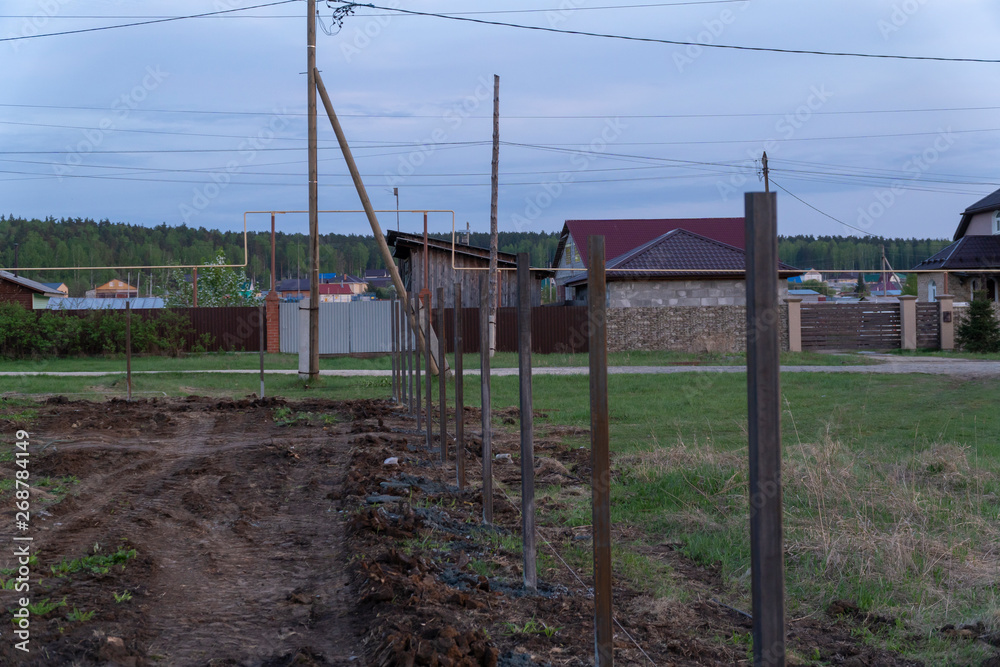 fence construction, concreted metall column. Evening, sunset fence construction, concreted metall column. Evening, sunset