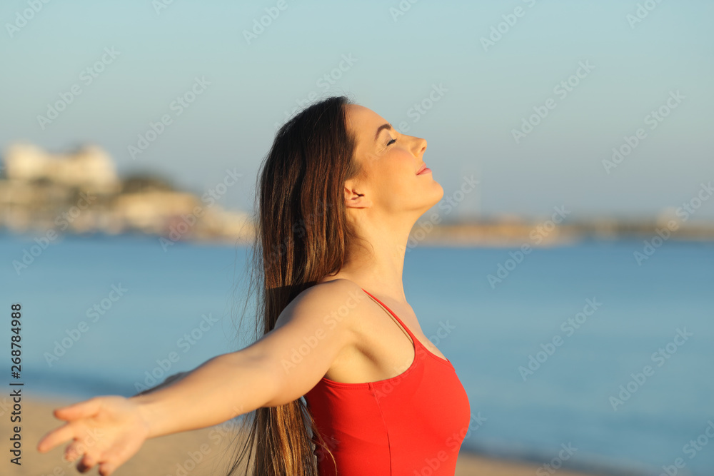 Relaxed girl in red breathing fresh air on the beach Relaxed girl in red breathing fresh air on the beach