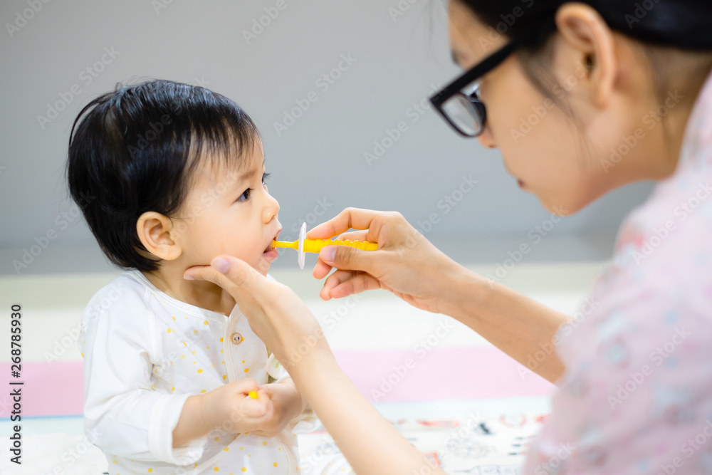 Mother is brushing her daughter teeth. Asian baby girl toothbrush by her mom. Mother is brushing her daughter teeth. Asian baby girl toothbrush by her mom.