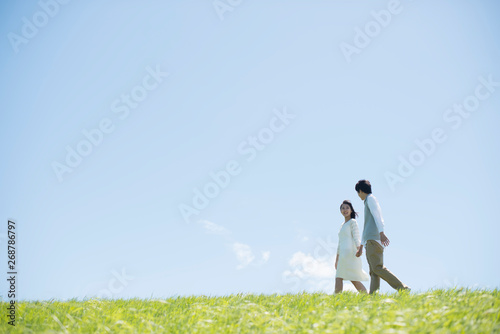 草原で手をつなぐカップル