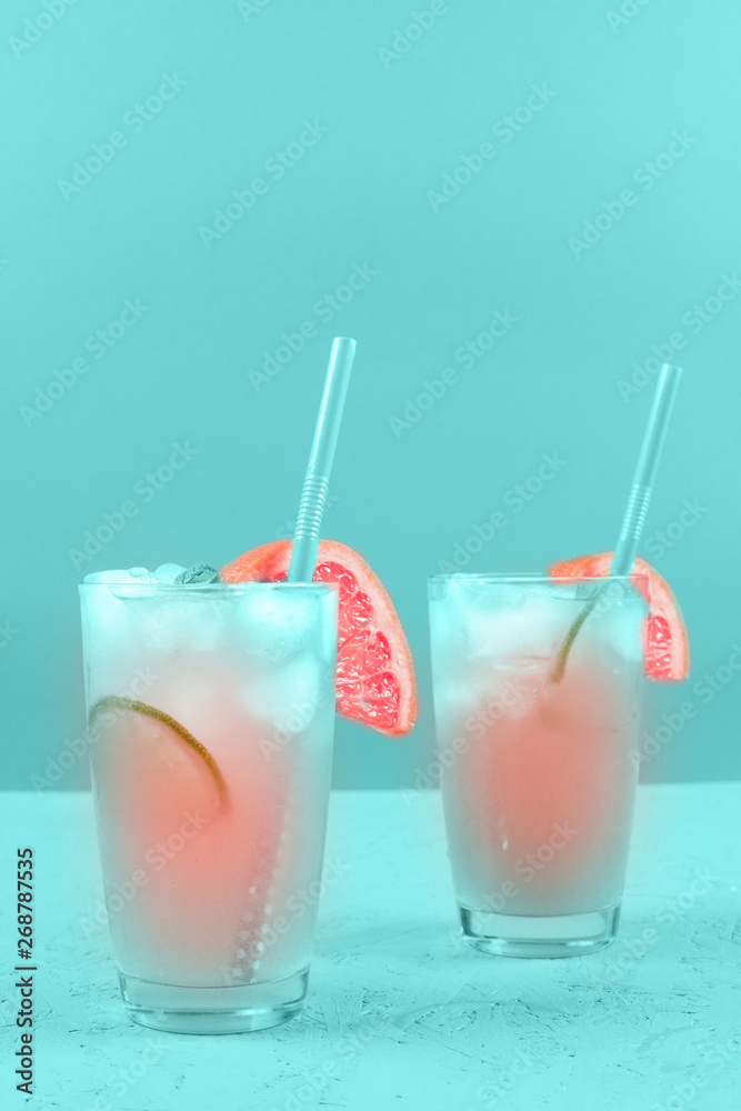 Two glasses of refreshment grapefruit cocktail on mint background Two glasses of refreshment grapefruit cocktail on mint background