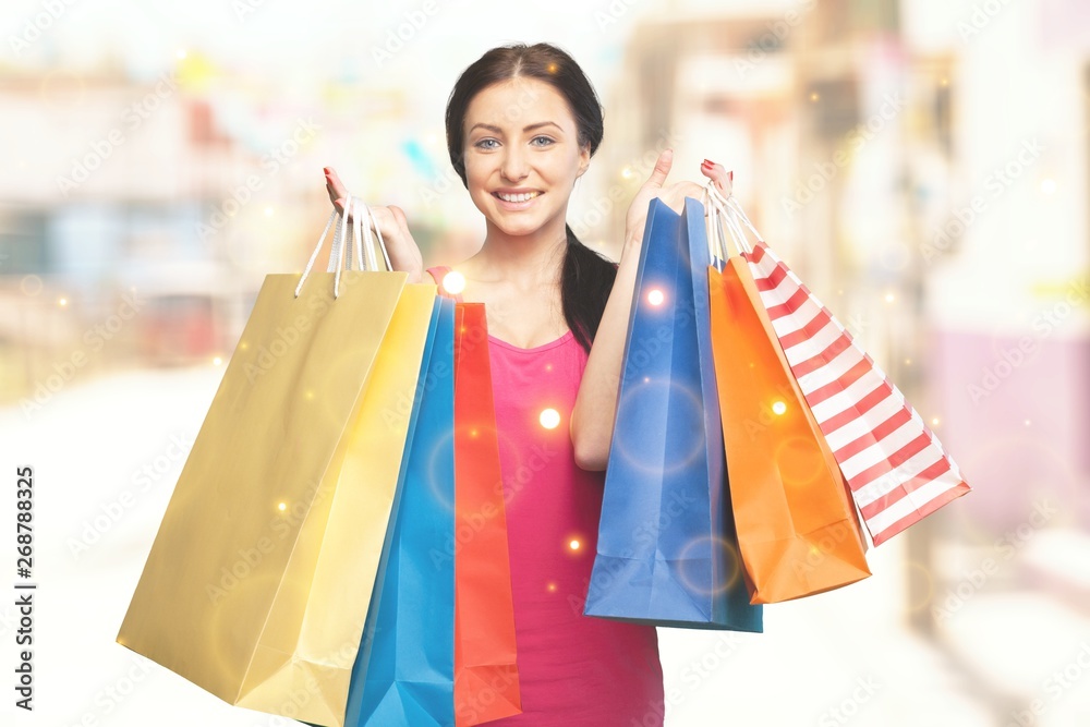 Young woman with shopping bags on background Young woman with shopping bags on background