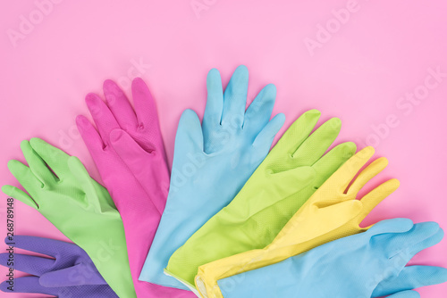 top view of multicolored rubber gloves on pink background