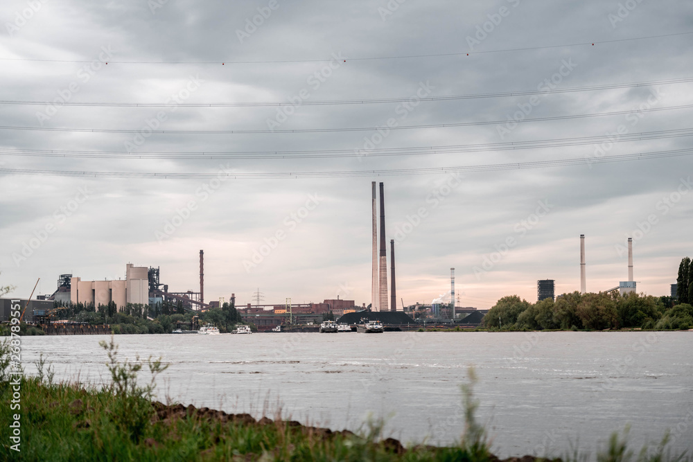 NRW/GERMANY - MAY 16, 2019: View of the industrial area with production plants next to the river rhine in Duisburg, Germany.