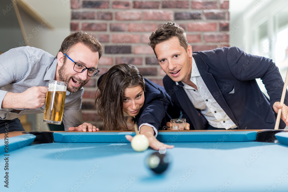 Fototapeta premium Happy friends enjoying playing snooker game and drinking beer.