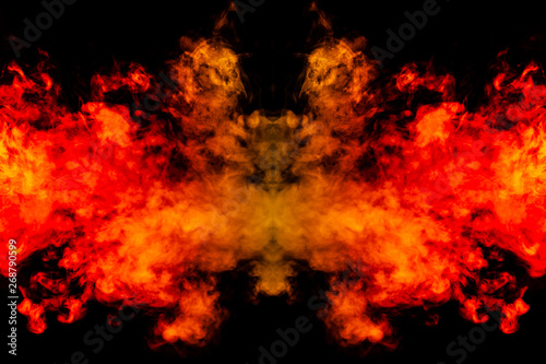 Smoke of different orange and red colors in the form of horror in the shape of the head, face and eye with wings on a black isolated background. Soul and ghost in mystical symbol