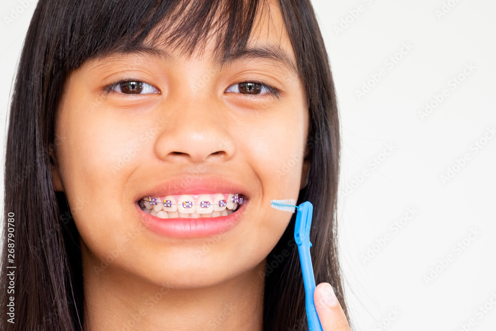 Girl with braces teeth hand holding toothbrush smiling and happy Girl with braces teeth hand holding toothbrush smiling and happy