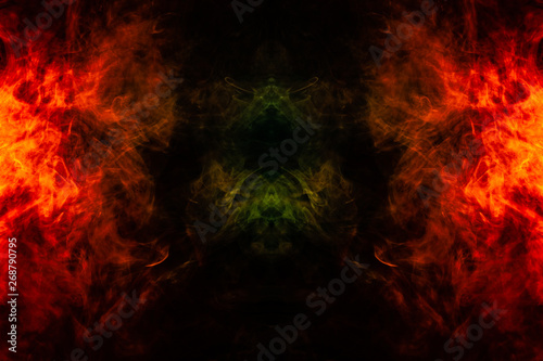 Smoke of different orange and red colors in the form of horror in the shape of the fire on a black isolated background. Soul and ghost in mystical symbol
