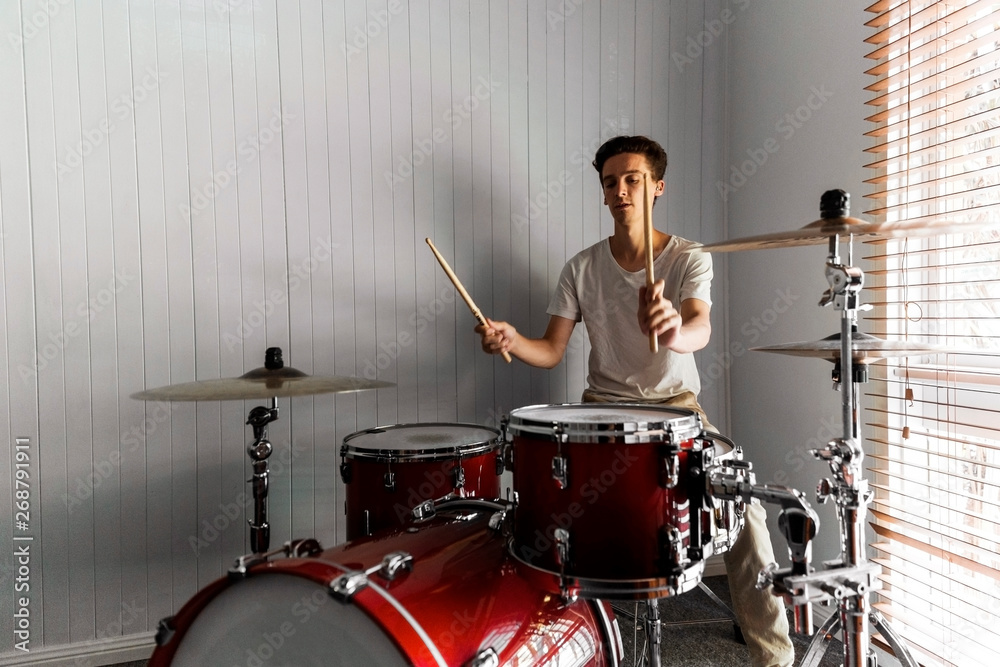 Fototapeta premium Highly skilled drummer working his magic in domestic practise room.