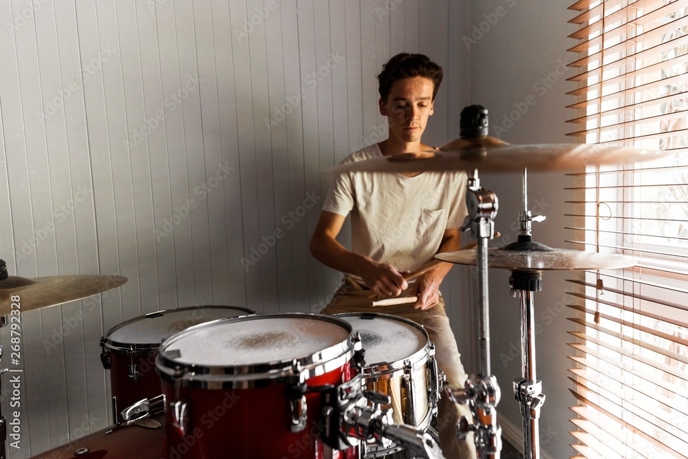 Enthusiastic drummer playing rock beat on practice drum kit. Enthusiastic drummer playing rock beat on practice drum kit.