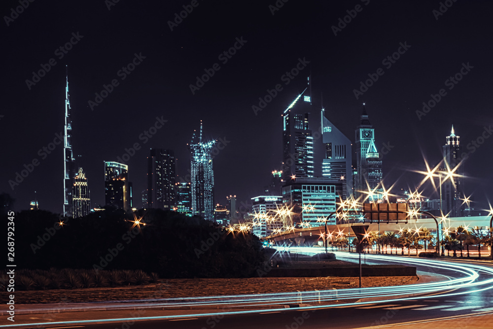 Fototapeta premium Night landscape with views of the skyscrapers and the Burj Khalifa from the side of the road
