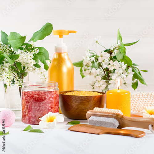 Spa and bath accessories with bath salts and beauty treatment products on white table. Wellness concept