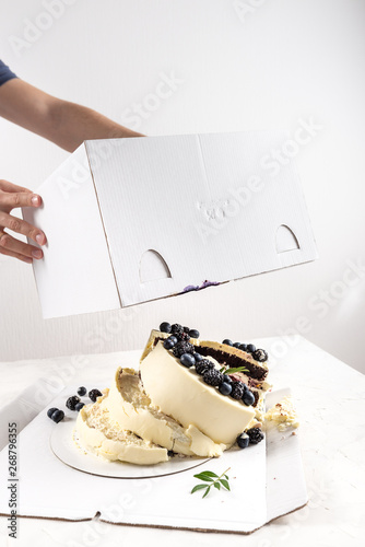 Broken cake inside the box on white background. Bad delivery concept. Spoiled birthday, wedding. Bad luck. Copy space
