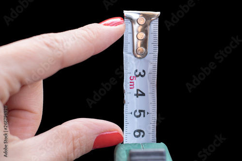 Construction tape measure in female hand. Size matters