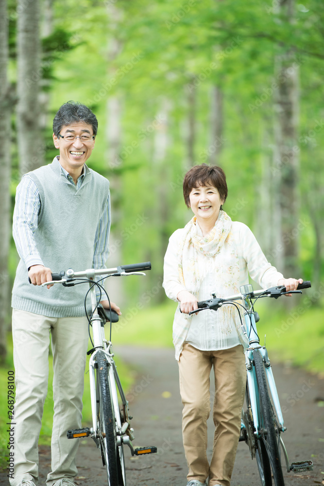 Obraz premium 自転車を押すシニア夫婦