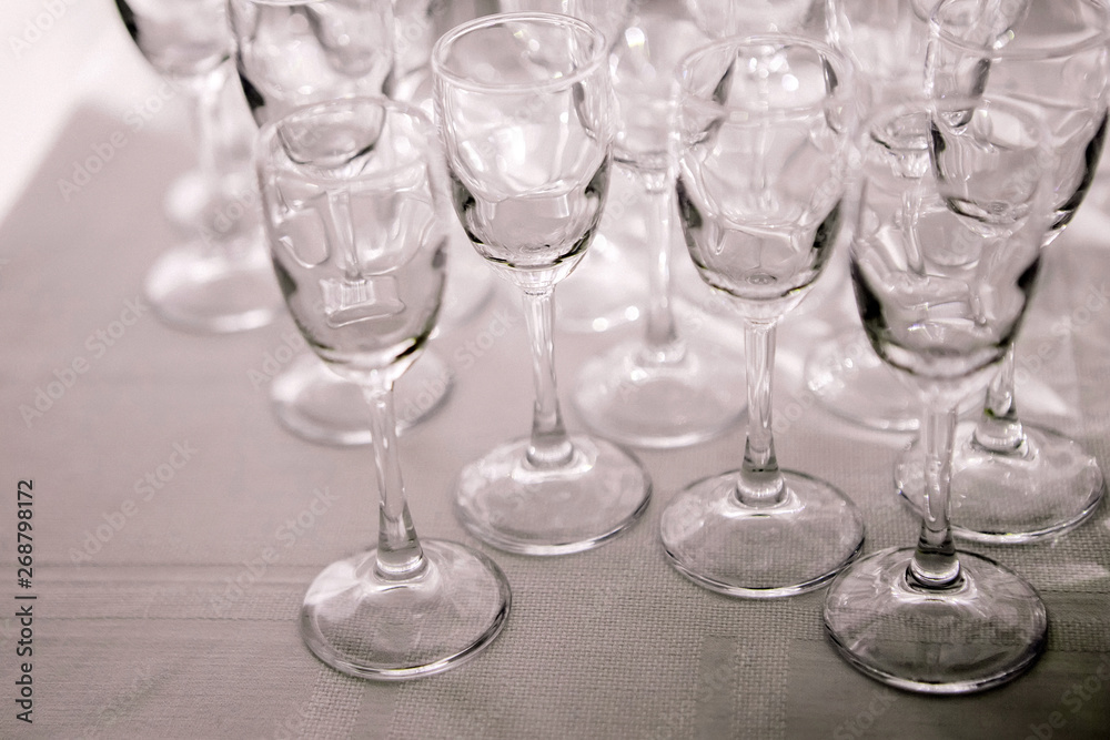 many empty liquor glasses many empty champagne glasses close up. glass goblets on the white table. Empty crystal wineglass. glass goblet on a high leg. many empty liquor glasses many empty champagne glasses close up. glass goblets on the white table. Empty crystal wineglass. glass goblet on a high leg.