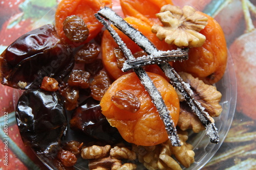 Vanilla sticks with spice cristals on plate with dry fruits and nuts photo