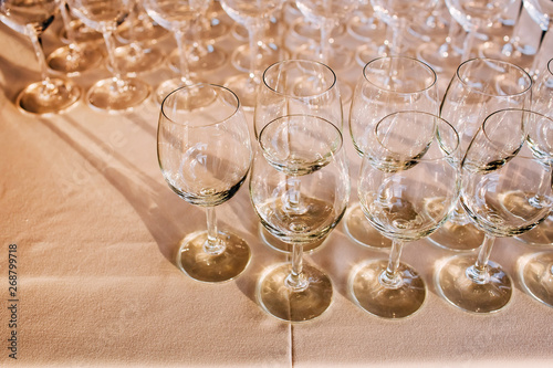 many empty champagne glasses close up. glass goblets on the white table. Empty crystal wineglass. glass goblet on a high leg.