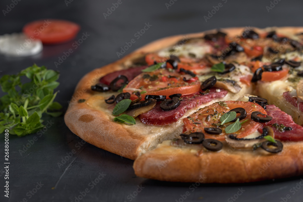 Hot sliced pizza, cheese bacon tomatoes, ham. on a dark Board. Hot sliced pizza, cheese bacon tomatoes, ham. on a dark Board.