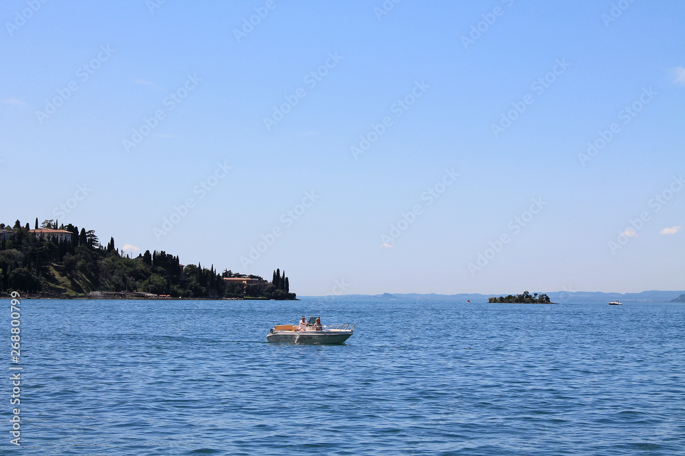 Summer landscape on lake Garda Italy with turquoise water and green mountains on the banks Summer landscape on lake Garda Italy with turquoise water and green mountains on the banks