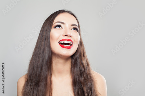 Happy woman in braces smiling and looking up
