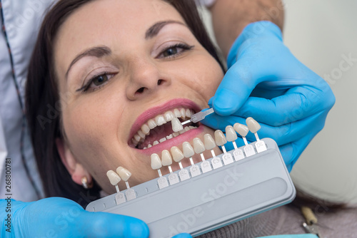 Doctor compare woman teeth with sampler in dentistry