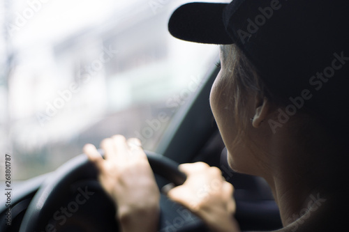 A woman driving and holding the steering wheel inside of a car. Drive safety concept.
