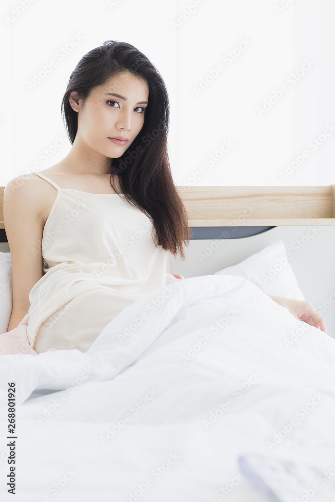 Asian woman model sitting and posing on bed.. Asian woman model sitting and posing on bed..