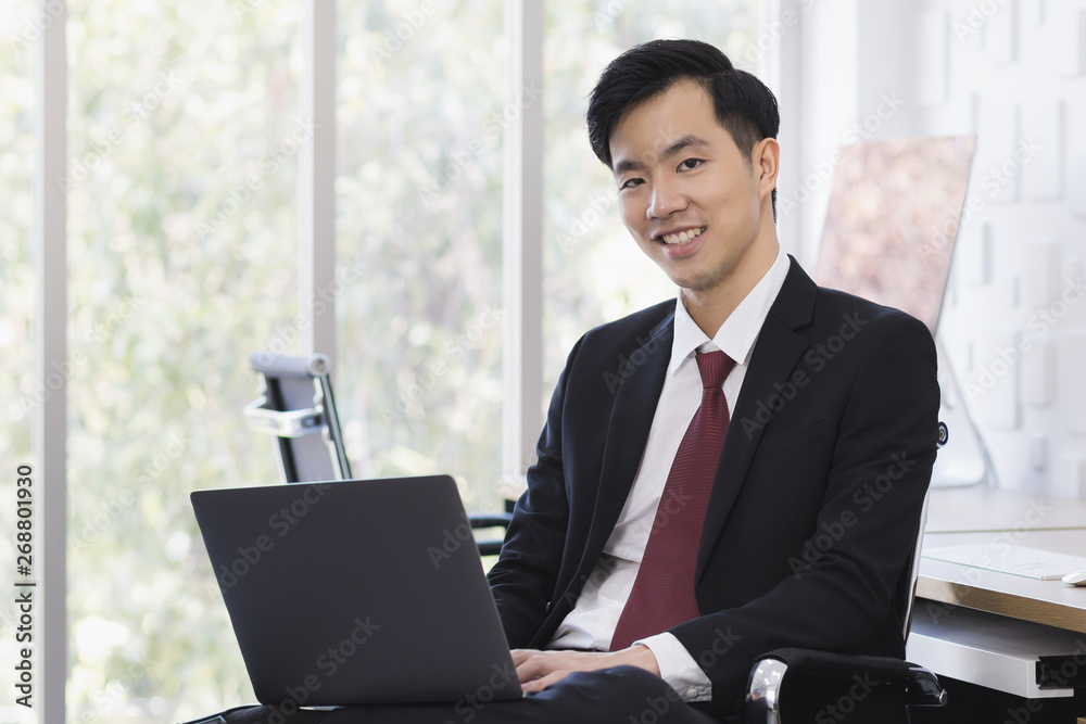 Asian Businessman using laptop in office.. Asian Businessman using laptop in office..