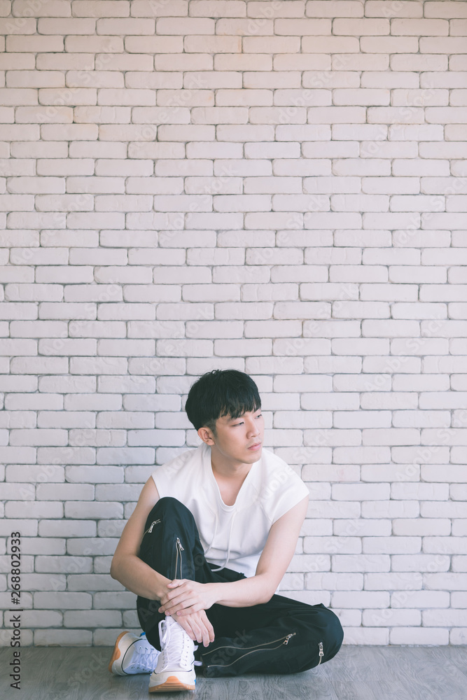 Asian model man sitting on floor and knee up..