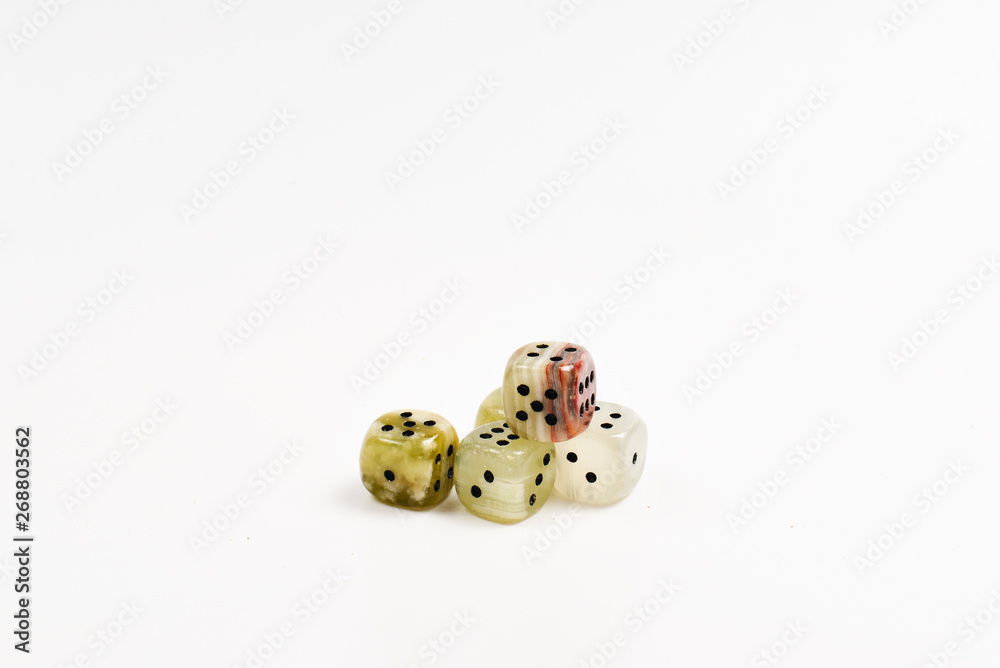 Dices made of natural stone on a white background. Copy space. Gaming. Dices made of natural stone on a white background. Copy space. Gaming.