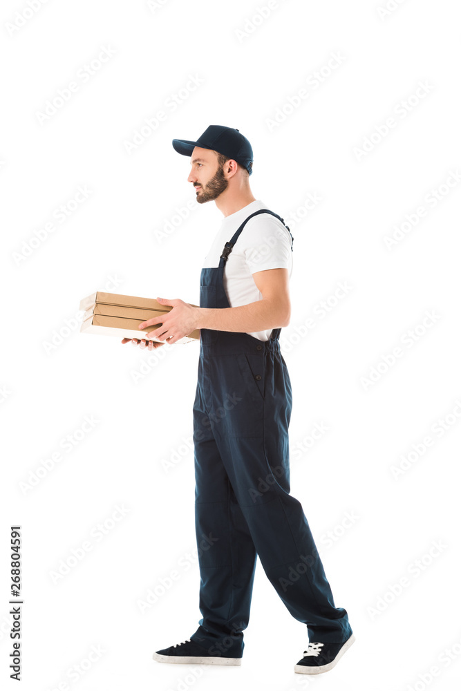 serious delivery man in overalls carrying pizza boxes isolated on white serious delivery man in overalls carrying pizza boxes isolated on white