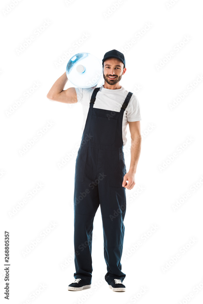 handsome delivery man holding bottle with water and smiling at camera isolated on white
