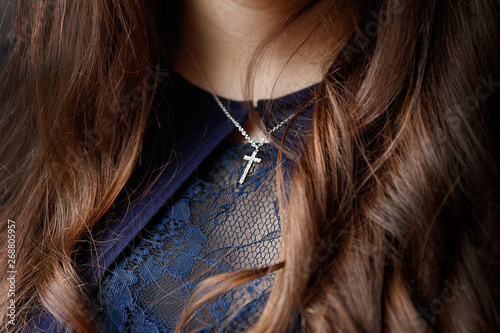 Mouth and chin of girl putting on a crucifix