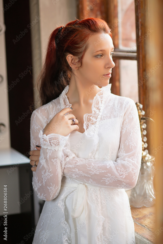 Fototapeta premium Portrait of a young pretty redhead lady.